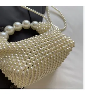 Detail of handmade pearl woven handbag showing exquisite bead craftsmanship and glossy texture