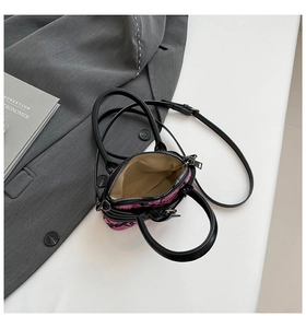 Top view of pink and black tweed bag interior showing silver zipper and leather strap