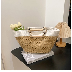 Close-up of woven tote bag with round wooden handles and decorative beaded details