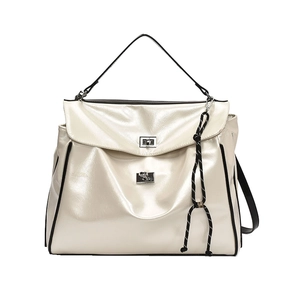 Creamy patent leather tote bag with metal twist lock and woven charm on white background