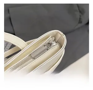 Close-up of high-quality silver metal zipper and hardware on beige bucket bag