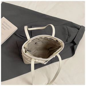 Top view showing the spacious interior compartment and zipper pocket of the white tote bag