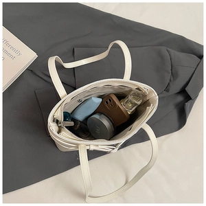 Internal view of the white bucket bag showing spacious storage with personal items