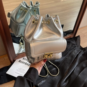 Silver metallic drawstring bucket bag with gold chain strap and buckle detail