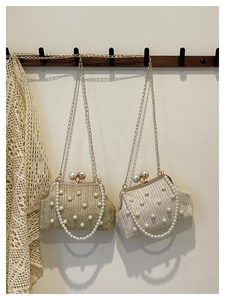 Detail of woven straw pearl handbags with gold hardware and chain strap in two neutral colors