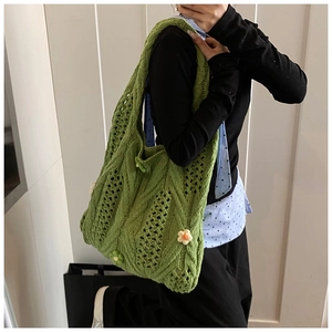 Detail of green knit shoulder bag with 3D daisy flowers and hollow crochet texture