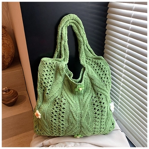 Detail of green knit tote bag featuring handmade 3D floral appliques and hollow textures