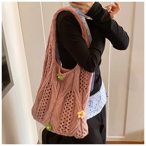 Detailed close-up of pink knit tote bag with 3D crochet flowers on a casual model