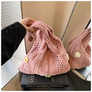 Close-up of pink hollow-out crochet tote bag with colorful 3D floral accents