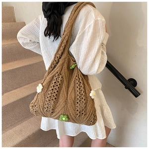 Detail of hand-woven crochet tote bag featuring 3D knit floral patterns and hollow texture