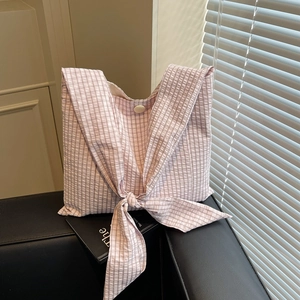 Pink checkered tote bag with large bow shoulder strap and button closure