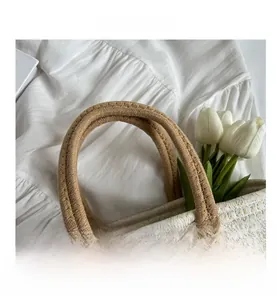 Close-up of thick woven handles and gold thread intertwined fabric on a stylish tote bag