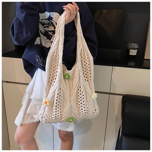 Detail of cream woven tote bag featuring colorful 3D floral knits and hollow texture