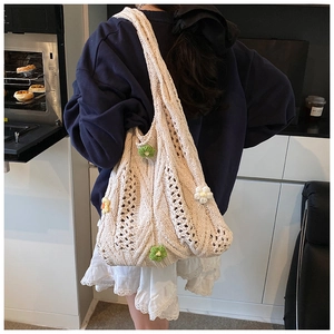 Detail of cream woven tote bag featuring hollow knit textures and 3D floral decorations