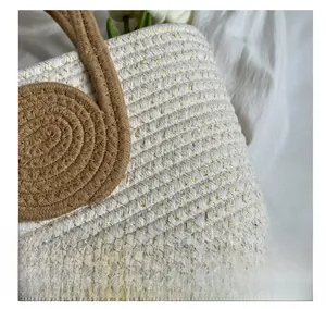 Detail shot of woven texture with gold threads and round knot handles on the handbag