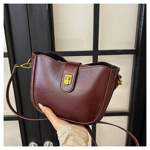 Detailaufnahme der weinroten PU-Leder Umhängetasche mit Vintage-Textur und Goldschnalle