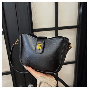 Detailansicht der schwarzen Bucket Bag aus Leder mit Retro-Struktur und Goldschnalle