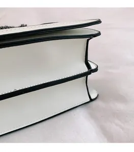 Gros plan du sac bandoulière blanc gaufré montrant le design multicouche et les bords noirs