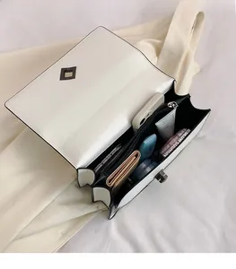 Vue intérieure d'un sac à bandoulière blanc vintage avec compartiments pour objets divers