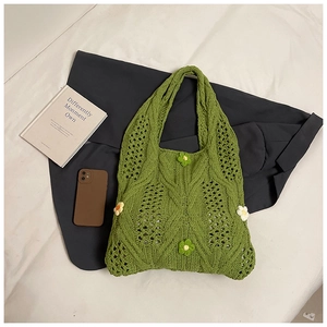 Detail of green hand-woven bag featuring 3D crochet flowers and intricate hollow knit pattern