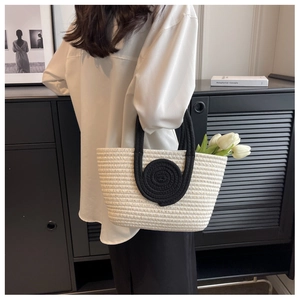 Detail of hand-woven off-white tote bag with black spiral accent and textured finish