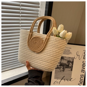 Detailed close-up of a woven tote bag with rope handles and decorative spiral design