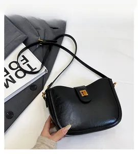 Detail einer Vintage-Eimertasche in Schwarz mit goldener Schnalle und Ledertextur