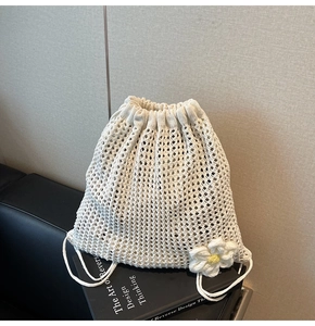 Detail of hollow woven shoulder bag with crochet flower and drawstring closure