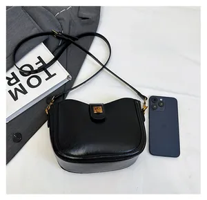 Detailansicht der schwarzen Lederbeuteltasche zeigt Stauraum mit Handy und Buch als Vergleich