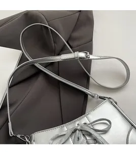Detailansicht der silbernen Metallic-Schultertasche mit Schnürung und verstellbarem Riemen