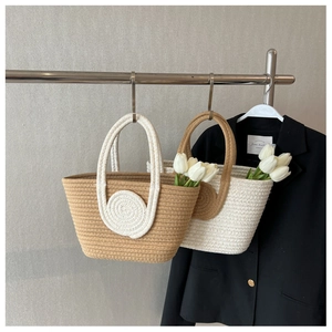 Detail of woven handbag with spiral accent on a metal hanger with tulip background
