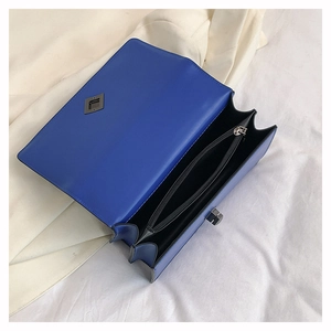 Vue intérieure du sac bandoulière en cuir bleu montrant deux compartiments et une poche zippée