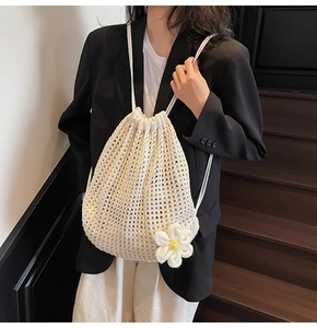 Detailed macro view of cream crochet drawstring bag with 3D daisy flower charm
