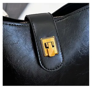 Nahaufnahme der schwarzen Ledertasche mit hochwertiger goldener Metallschnalle und Textur