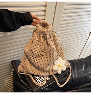Macro detail of beige crochet backpack featuring hollow weave and small floral accent