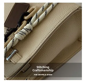 Macro view of lychee pattern leather handbag with contrast stitching and woven rope detail