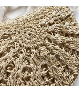 Close-up of the intricate hand-woven straw texture on a beige summer beach crossbody bag