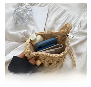 Vue intérieure d'un sac à bandoulière en paille tressée beige avec espace pour téléphone
