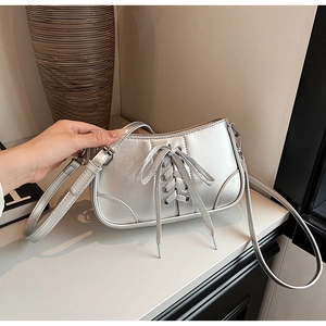 Detailansicht der silbernen Handtasche mit Schnürung und metallischem Oberflächenfinish