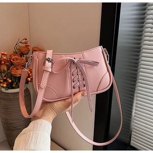 Detail der rosa Schleifen-Handtasche mit verstellbarem Riemen und Schnürung im Licht