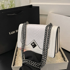 Sac bandoulière blanc à motif serpent avec chaîne noire et fermoir losange