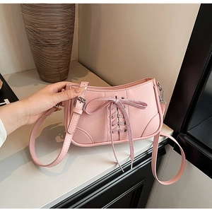 Detailansicht der rosa Lackleder-Handtasche mit Schleifendekor und Schnürdesign