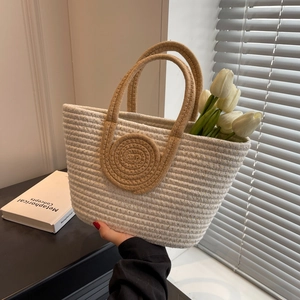 Modern woven tote bag with brown handles and floral accents in a natural light setting