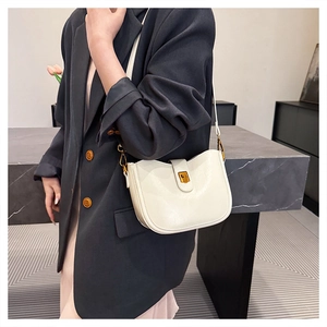 Nahaufnahme der weißen Leder-Schultertasche mit einem eleganten goldfarbenen Metallverschluss