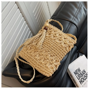 Detail der böhmischen handgefertigten Strohtasche mit Fransen und Holzperlenakzenten