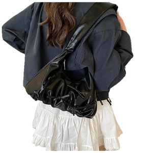 Chic black pleated hobo bag with leather bow details and comfortable wide shoulder strap
