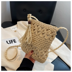 Details der handgefertigten Häkeltasche mit Blumenmustern und Perlenfransen