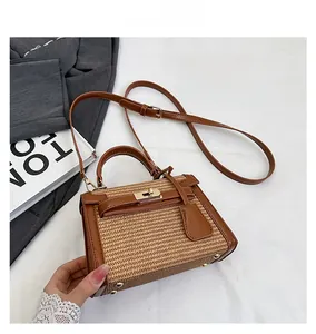 Detail shot of the woven straw texture and premium brown leather trim on the Kelly bag
