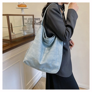 Detail of light blue glitter fabric tote bag showing soft hobo texture on model