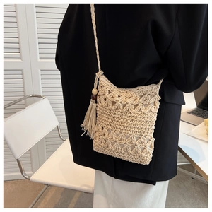 Détail du sac en paille tissé main avec motifs floraux ajourés et glands en perles de bois